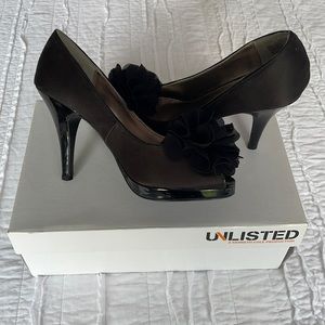 Unlisted black heels with flower on front.